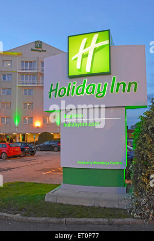 Holiday Inn Hotel sign illuminated at dusk with hotel building beyond Basildon Essex England UK Stock Photo