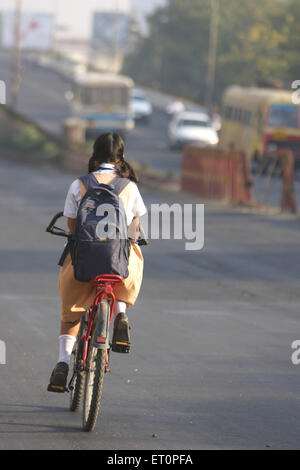 School girl riding on bicycle with school bag ; Nagpur ; Maharashtra ; India ; Asia Stock Photo