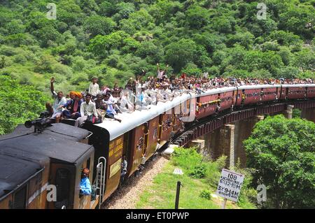 People traveling crowded on roof of train risky dangerous railway travel Jodhpur Rajasthan India Asia Asian Indian Stock Photo