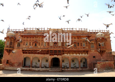 Woman peeping through window from haveli ; Rajasthan ; India Stock Photo