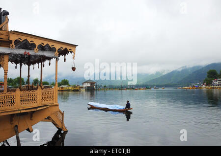 Houseboat and canoe in dal lake ; Srinagar ; Jammu and Kashmir ; India Stock Photo