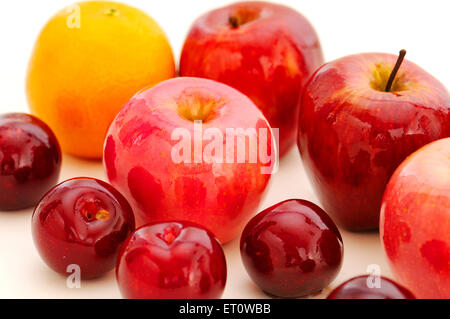 apples oranges plums on white background Stock Photo