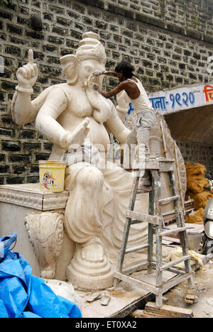 Man making idol of Lord Ganesh , Chitrashala , Ganapati Festival , Lalbaug , Bombay , Mumbai , Maharashtra , India , Asia Stock Photo