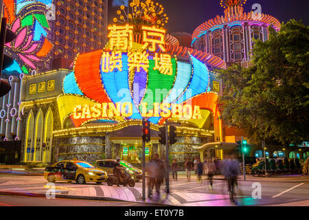 Crowds and traffic pass the exterior of Casino Lisboa in Macau, China.