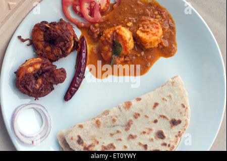 Fried prawns with gravy and chapatti in plate ; Kovalam ; Trivandrum Thiruvananthapuram ; Kerala ; India 2010 Stock Photo