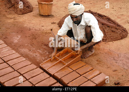 worker moulding earthen bricks ; Tamil Nadu ; India Stock Photo