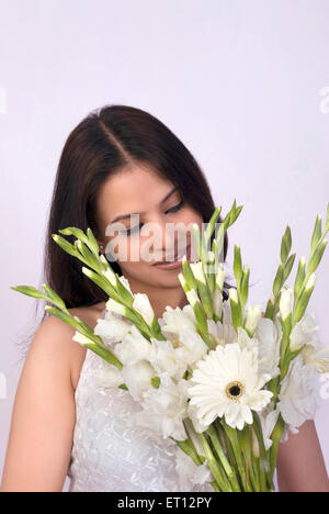 Christen bride in white gown looking at flowers MR#733C Stock Photo