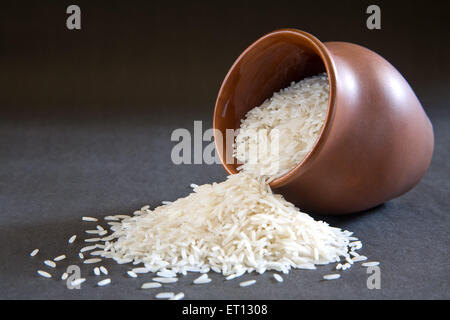 Basmati rice in earthen pot spread on black background Stock Photo