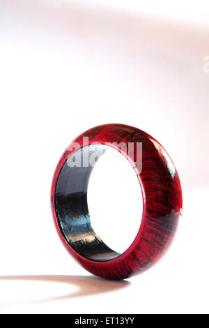 Maroon and black colors on wooden bangle on white background Stock Photo