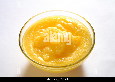 Ghee - pure granular homemade golden yellow ghee in glass bowl on white background Stock Photo