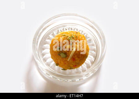 Mithai ; one piece of mithai motichur or boondi dryfruit laddoo in round glass plate on white background Stock Photo