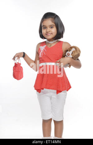 Young girl showing red purse holding stuffed toy MR#719D Stock Photo