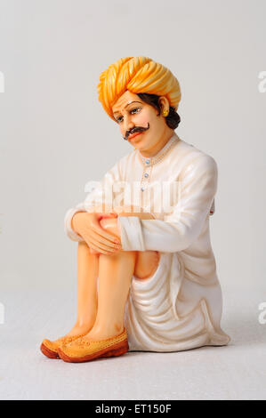 Clay figurine ; statue of rajasthani man wearing dhoti and turban in sitting position Stock Photo