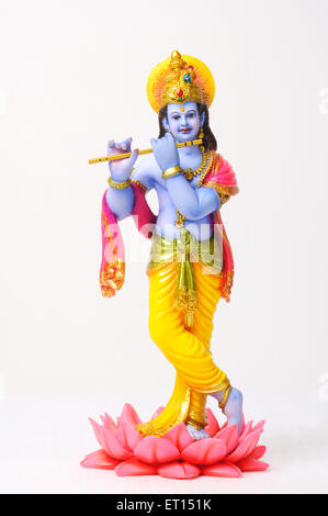 Clay statue of god krishna playing flute standing on lotus Stock Photo