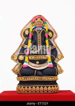 Clay statue of lord ganesh on red cloth Stock Photo