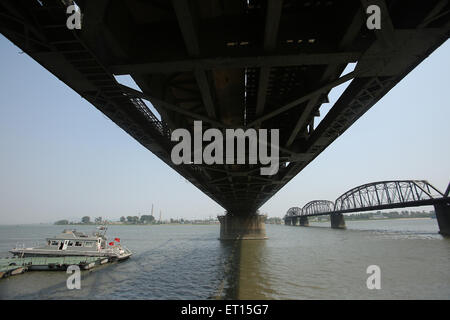 Dandong, LIAONNG PROVINCE, CHINA. 27th May, 2015. Korean, Japanese and Korean tourists visit the American bombed Yalu River Jiang Duan Qiao Bridge (R) as trade continues with North Korea (background) and China on the Friendship Bridge (L), in Dandong, China's larger border city with North Korea, in Liaoning Province, on May 27, 2015. China remains North Korea's most important ally, providing Pyongyang with most of its food and energy supplies and comprises over sixty percent of its total trade volume. North Korea's economic dependence on China continues to grow due to international sanctions Stock Photo