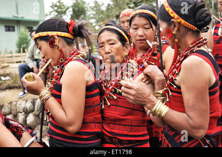 Naga tribe women smoking pipe ; Kohima ; Kisama village ; Nagaland ; North East ; India NOMR Stock Photo