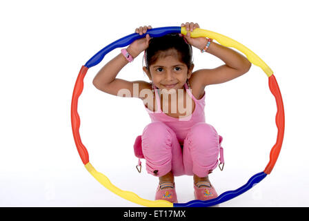 Girl playing with toy hula hoop exercise ring on white background MR#736M Stock Photo
