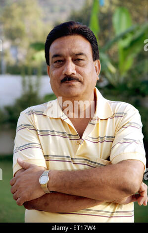 Indian adult man hands crossed in tshirt wrist watch green garden  background - MR#784E - RMM 178252 Stock Photo