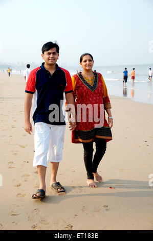 Couple holding hands walking on the beach MR#736J&K Stock Photo