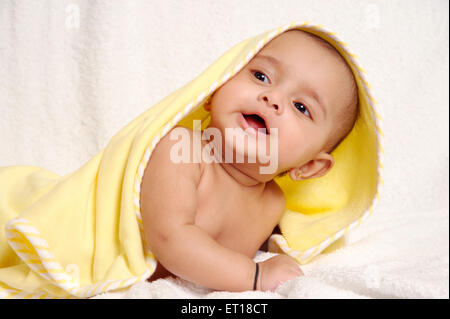 Baby wrapped in yellow towel looking up on white background - MR#736LA - RMM 179717 Stock Photo