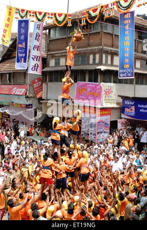 Human pyramid trying to break dahi handi in janmashtami gokulashtami festival ; Bombay Mumbai ; Maharashtra ; India Stock Photo