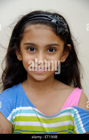 Six years old Indian girl portrait open hair band looking at camera MR#736L Stock Photo