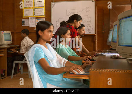 Teacher teaching computer knowledge to rural youth in class socio economic initiative started by NGO Chinmaya Organization India Asia Stock Photo