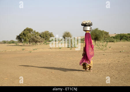 Woman carrying water in Jaisalmer at Rajasthan India Stock Photo