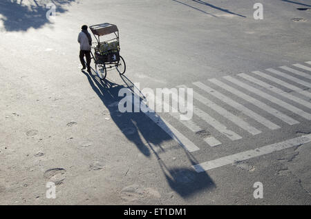 Rickshaw driver dragging cycle rickshaw in Jaipur at Rajasthan India Stock Photo