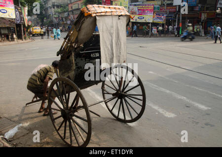 Hand rickshaw puller taking rest Kolkata West Bengal India Asia Stock Photo