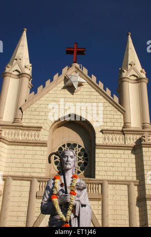 St. Patrick cathedral with red cross and star on top and statue of Jesus with lamb ; Pune ; Maharashtra ; India Stock Photo