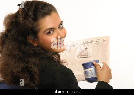 Woman with mug and newspaper MR#686M 20 March 2010 Stock Photo