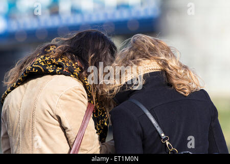 Two young women turning around to check their photo after taking a selfie Stock Photo