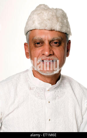 Portrait of Maharashtrian elderly man wearing white kurta and furry cap Pune Maharashtra India MR # 686P Stock Photo