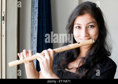 A portrait of maharashtrian girl playing a flute Pune Maharashtra India Asia MR # 686EE Stock Photo