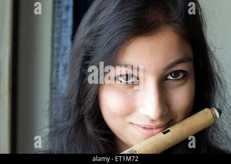 A face portrait of maharashtrian girl playing flute Pune Maharashtra India Asia MR # 686EE Stock Photo