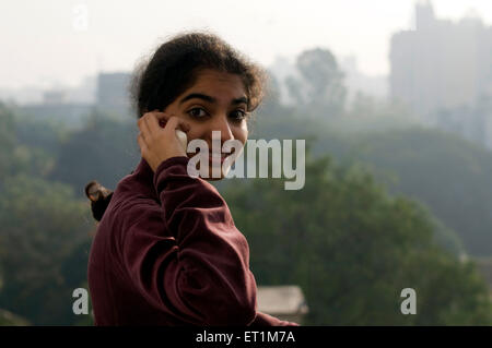 A girl talking on mobile phone in winter morning Pune Maharashtra  India Asia MR# 191 1 Stock Photo