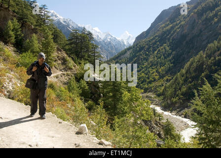 Trekker coming from gomukh of ganga river and Himalayan landscape ; Uttaranchal ; India Stock Photo