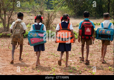 Students with heavy bags going to school in a village, Maharashtra, India, Asia, Indian, Asian Stock Photo