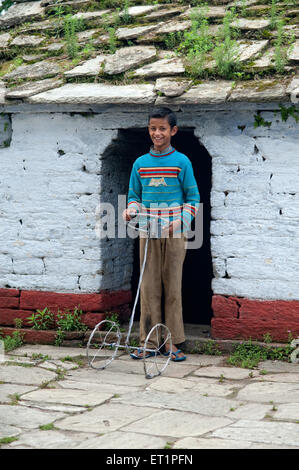 Boy playing with handmade wheel, Syahi Devi Temple, Sitlakhet, Shitlakhet, Almora, Uttarakhand, India, Asia, Asian, Indian Stock Photo
