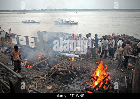Dead bodies burnt at Manikarnika Ghat on river Ganges at Varanasi Uttar Pradesh India Asia - sub 179620 Stock Photo