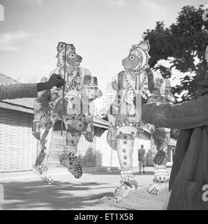 Men displaying transparent painted leather puppets ; Shadow puppet plays entertainment ; Hallare village ; Mysore ; Karnataka Stock Photo