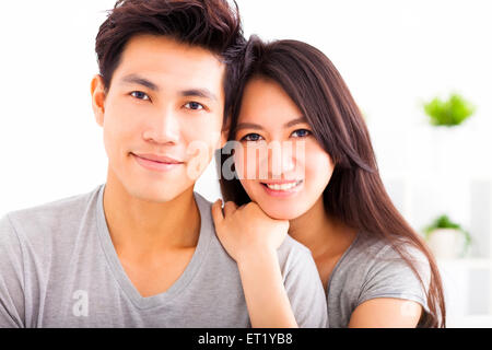 A cute young Asian girlfriend is hugging her boyfriend while