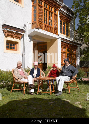 Family sitting in hotel garden Tingmosgang Ladakh Jammu and Kashmir India MR#477 Stock Photo