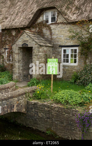 Vote green party. A political placard in a rural cottage garden supports the Green Party in the 2015 UK general election. Dorset, England, UK. Stock Photo
