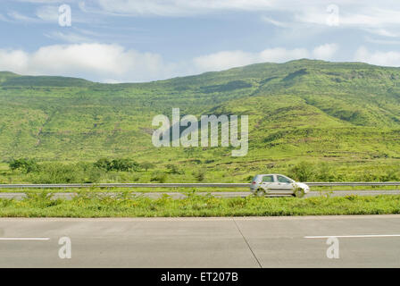 Car zooms past on the Mumbai Pune express way ; Maharashtra ; India Stock Photo