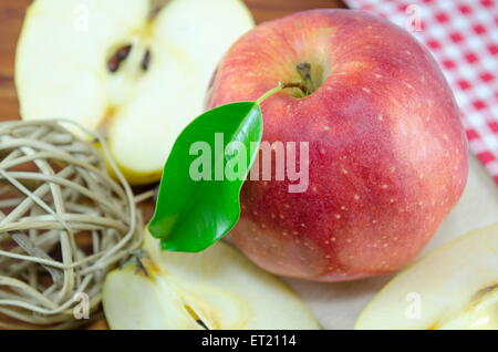 Halved and whole red apple on a table with a handmade decoration Stock Photo