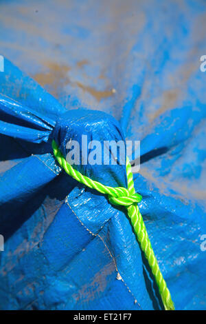 Nylon green thread knot on blue plastic Stock Photo