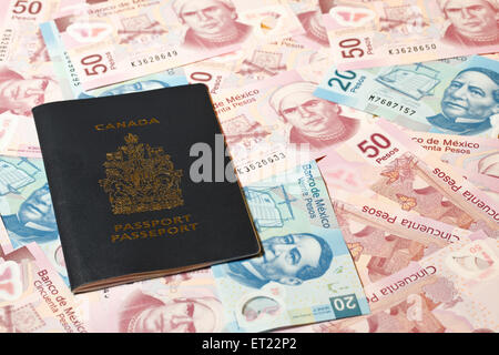 Canadian passport on a background of 20 and 50 Mexican pesos bills Stock Photo